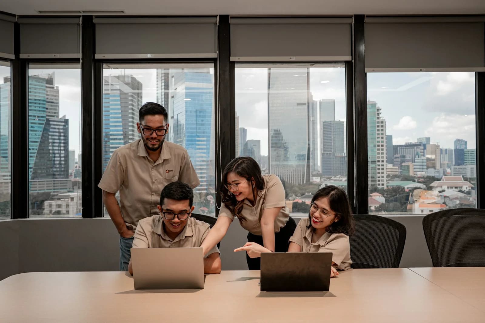 Diverse enterprise technology team collaborating around laptops in a modern office — strategic resourcing across SAP, cloud, AI engineering, data, DevOps, and cybersecurity